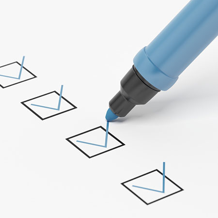 A blue marker checking boxes on a piece of paper